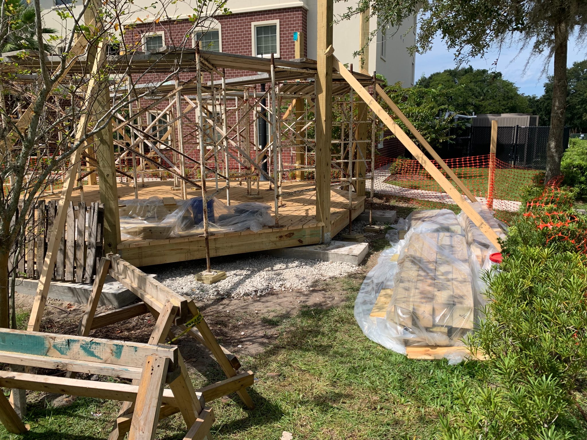 Construction of wooden deck addition with metal framing and protective sheeting on residential property