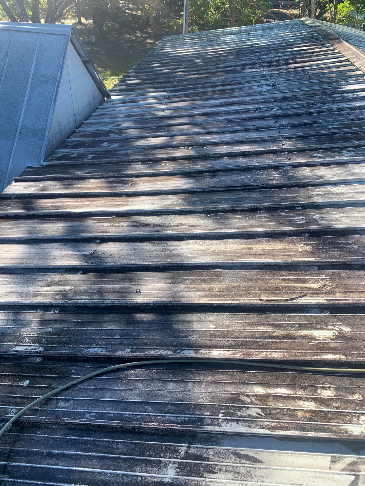 Weathered wooden deck with dark stain and visible wear, blue storage box on left side