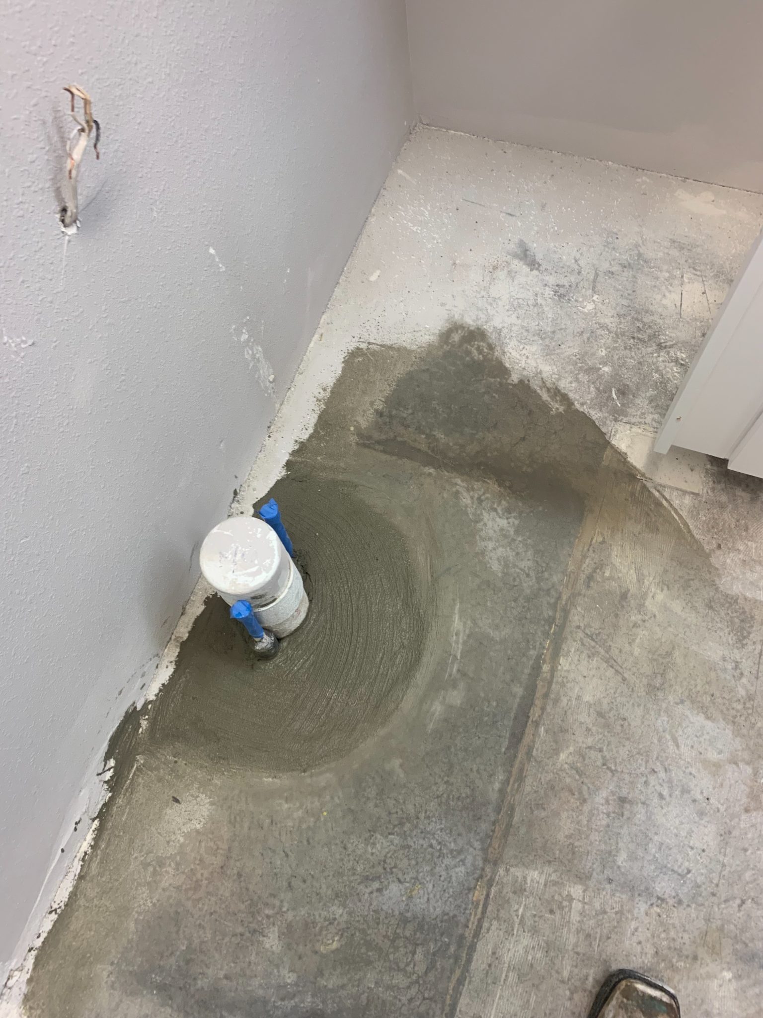 Concrete floor being smoothed with trowel during construction renovation work
