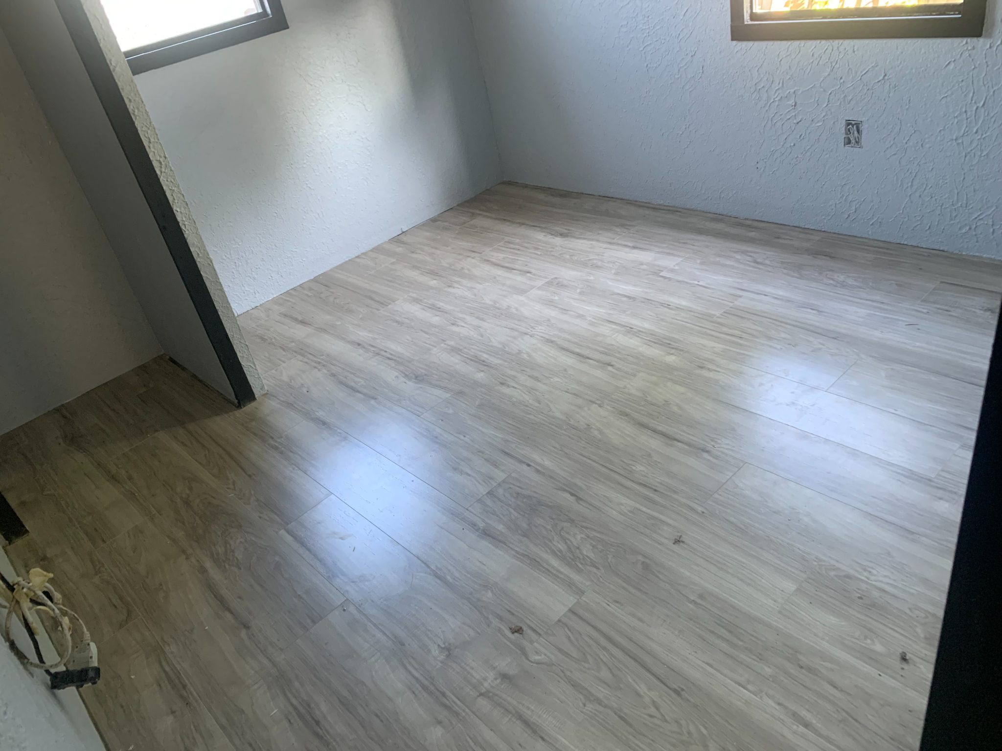 Empty room with light gray wood-look flooring and white textured walls