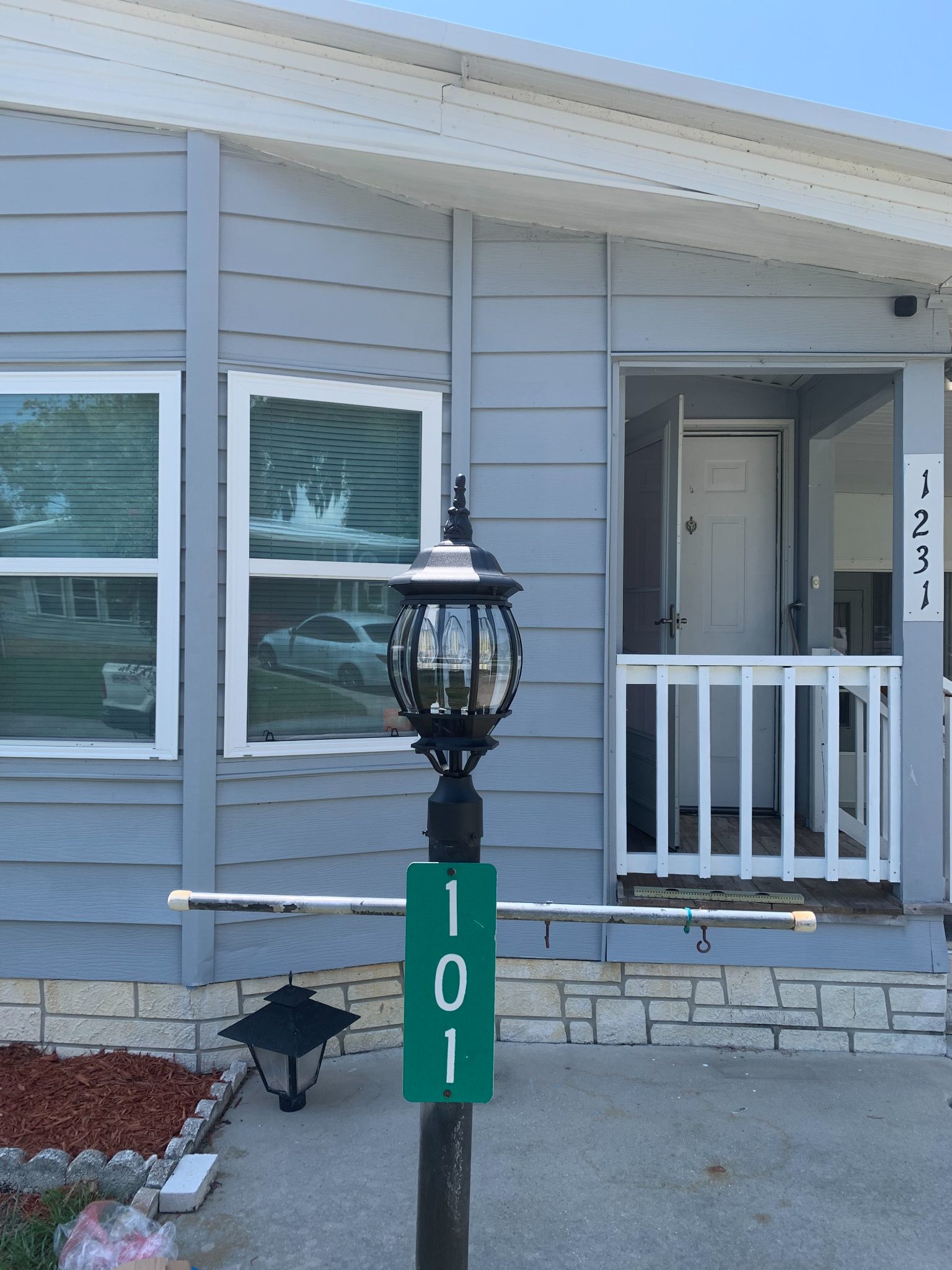 Front exterior of house 101 with green address marker and black lamp post