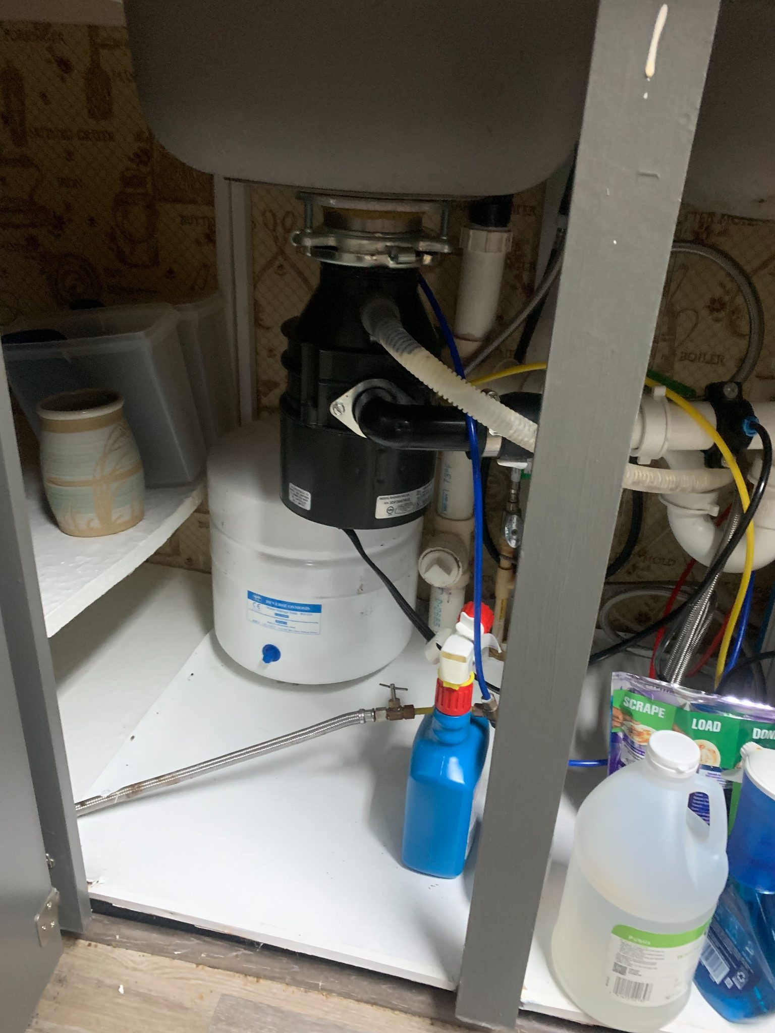 Under-sink water filtration system with storage bottles and plumbing connections